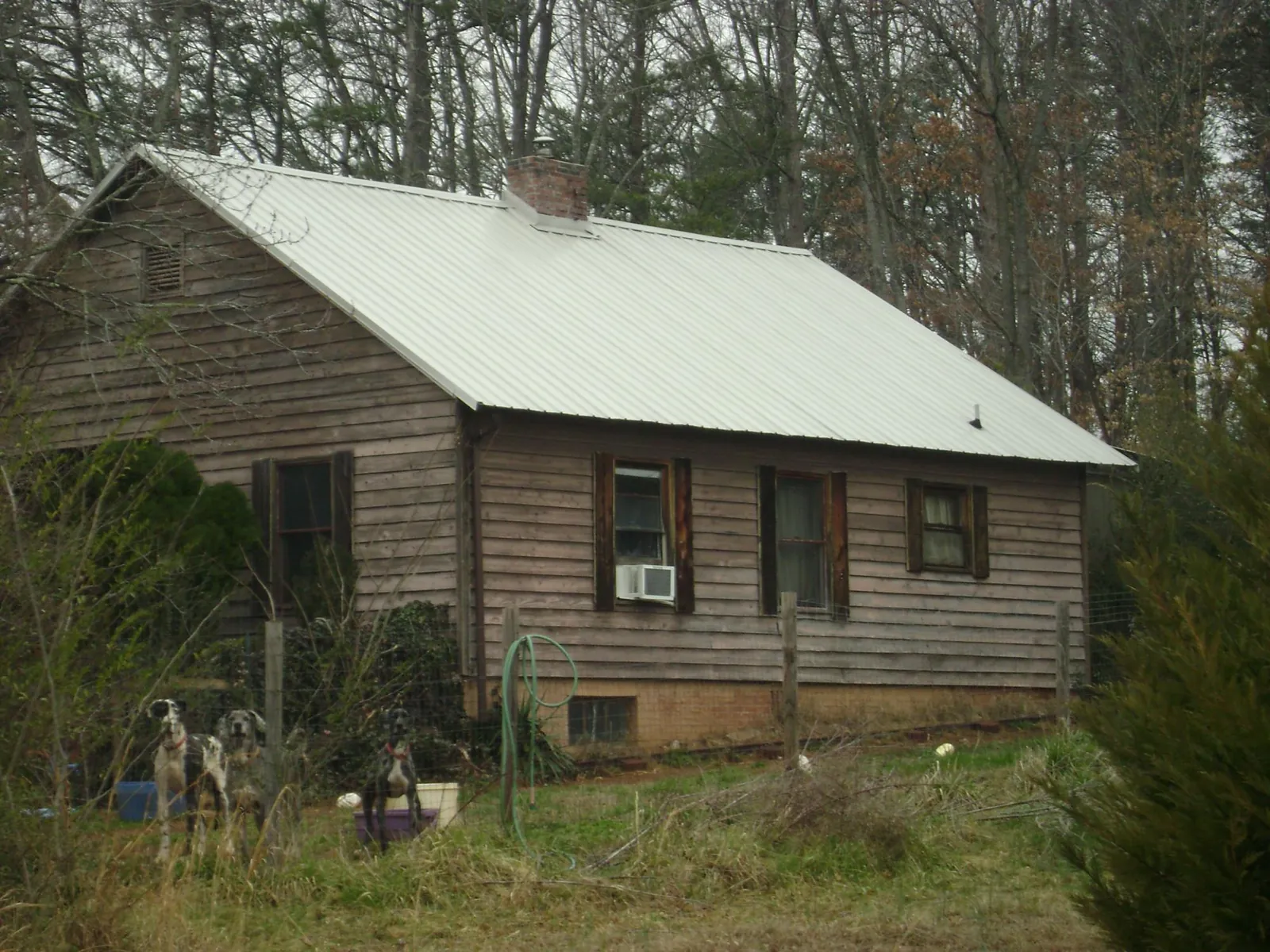 White metal roof on an old wood sided farmhouse, from a Metal Roof Installation job in Hill City